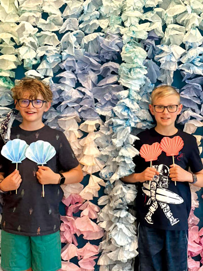 Kids pose with their ocean-themed crafts in a photo booth at the Agave Public Library in Phoenix, AZ.