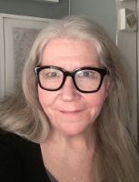 Kimberly Olson Fakih, an older woman with long gray hair and black glasses